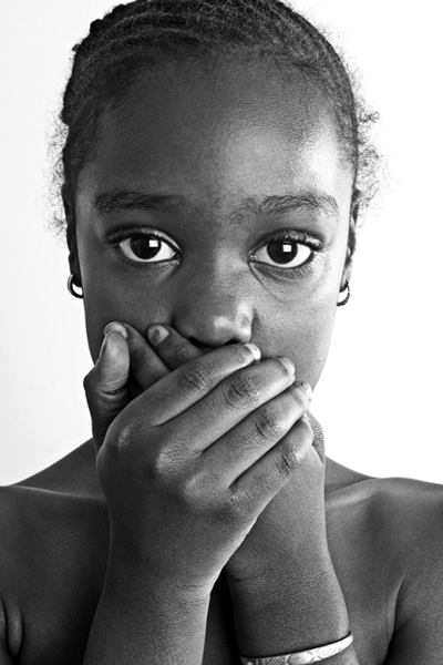 Young girl covering her mouth with both hands