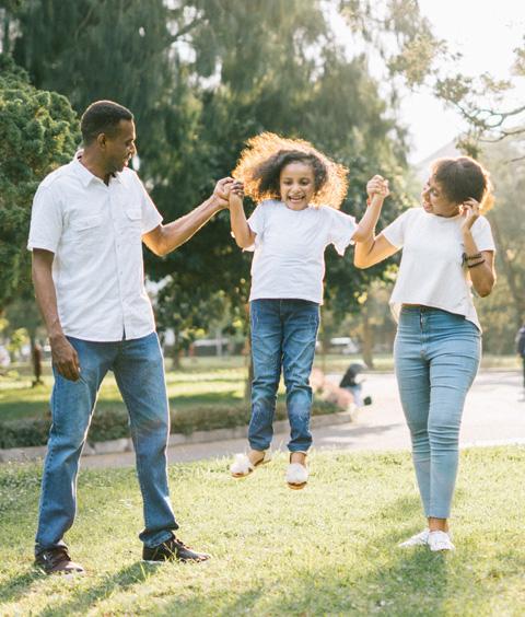 A man and a woman assisting a girl while jumping